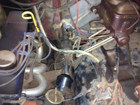 Engine bay with brake fluid reservoir, distributor, spark plug wires, and various hoses