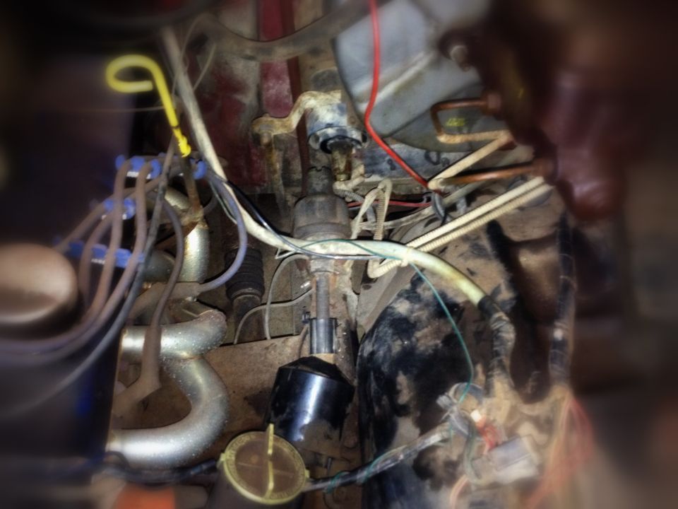 1984 Ford Bronco engine compartment with distributor, spark plug wires, and exhaust manifold visible