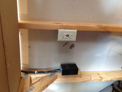 Photo of a GFCI outlet and junction box on a garage wall