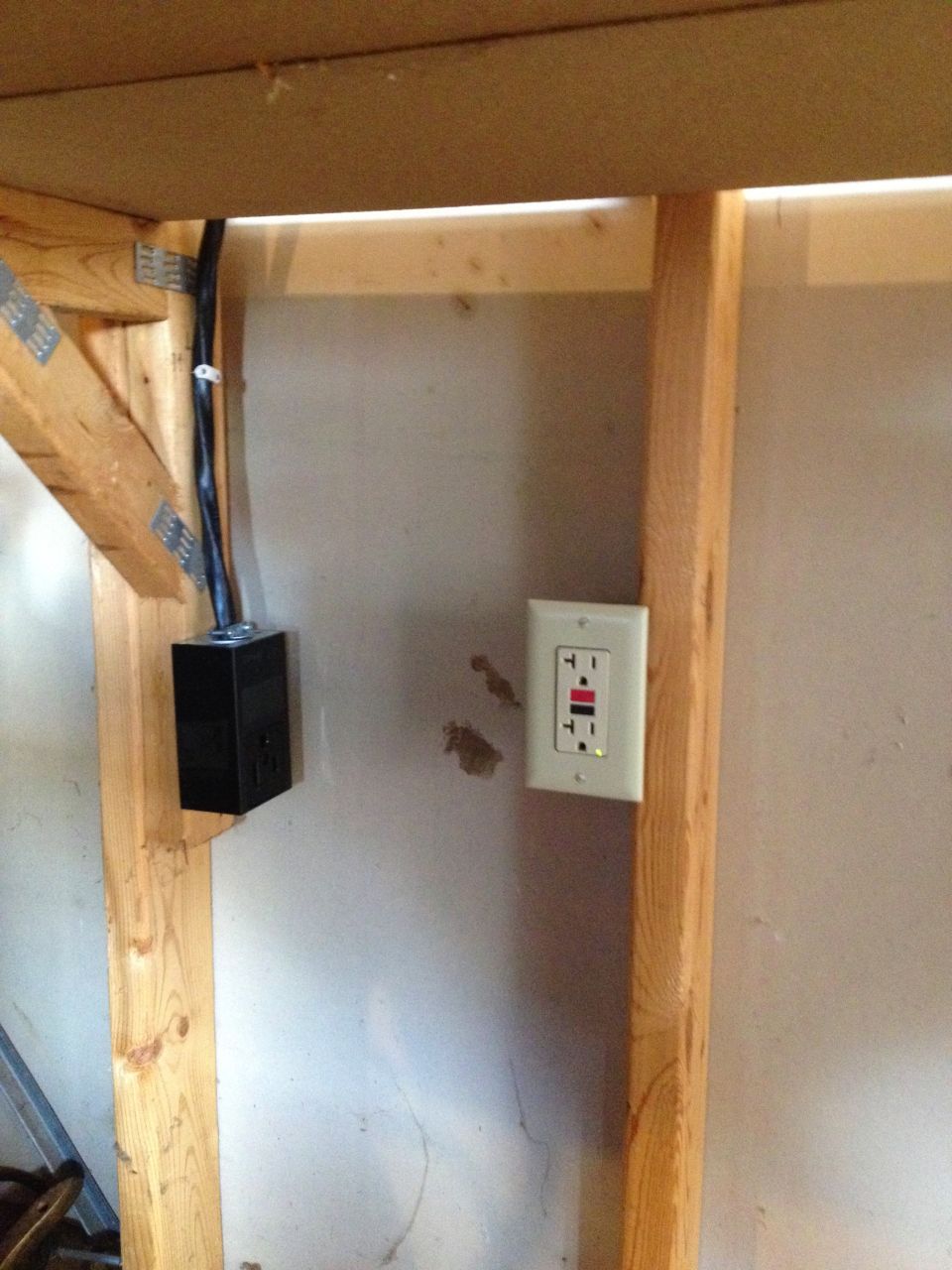 Photo of a GFCI outlet and junction box on a garage wall