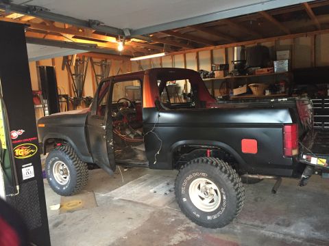 Photo of a black Bronco with door open in a garage