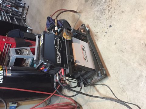 Photo of a plasma cutter and welding equipment on a garage floor