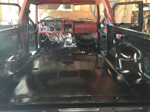 Photo of a vehicle cab interior with painted black floor and dash