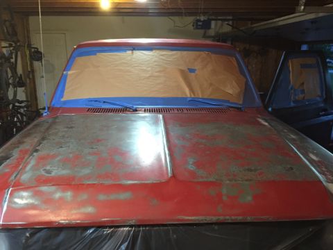 Truck front with hood and windshield masked for paint in a garage