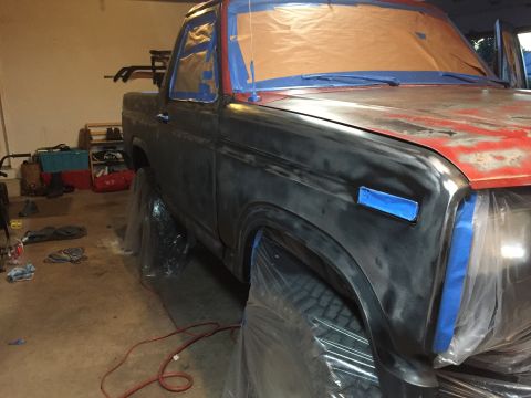 Side view of project truck in black primer in a garage