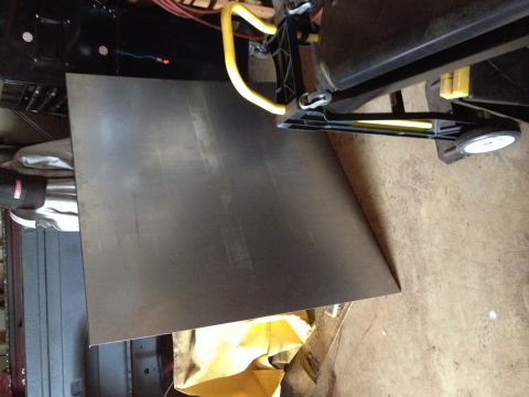 Flat metal sheet panel resting on a stand in a garage