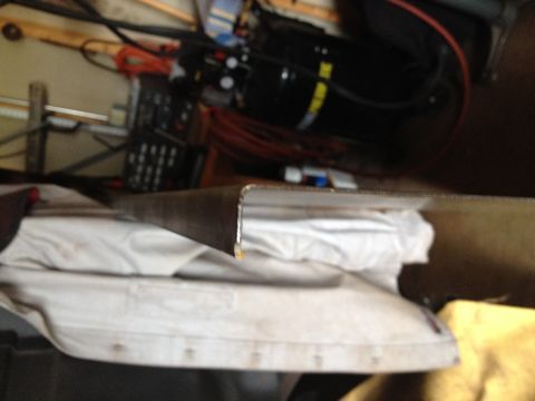 Close-up of a metal panel edge during fabrication in a garage
