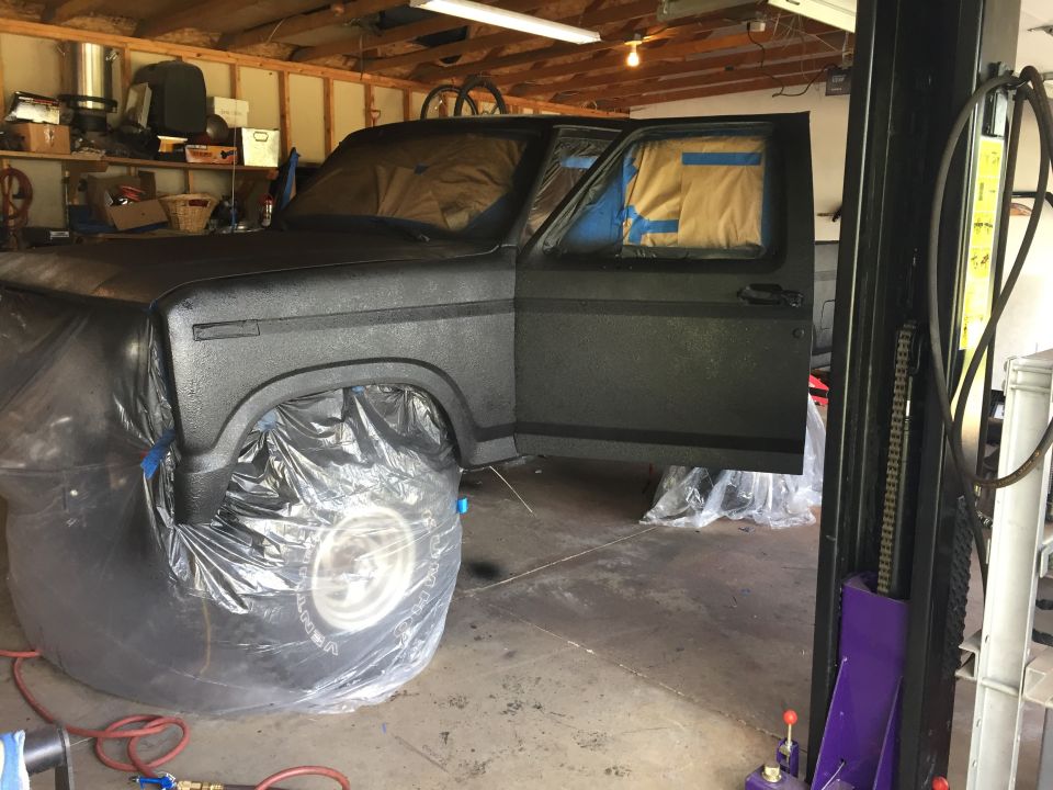 Project truck in black coating with wheels bagged on a lift