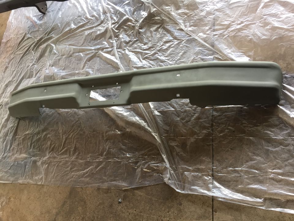Freshly painted truck front bumper on plastic sheeting