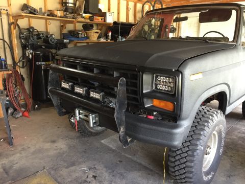 Gray Ford Bronco-style truck front three-quarter view in a garage