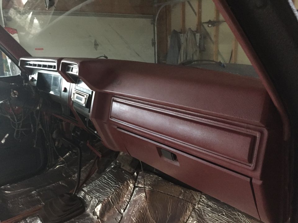 Maroon dashboard and glovebox of a Ford truck interior