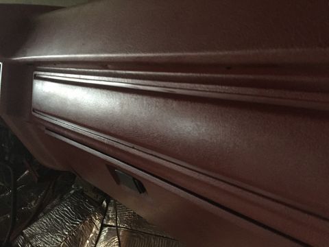 Close-up of a maroon vehicle dashboard panel