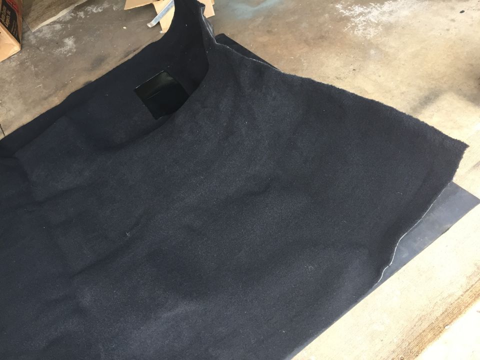 Black molded automotive carpet on a garage floor