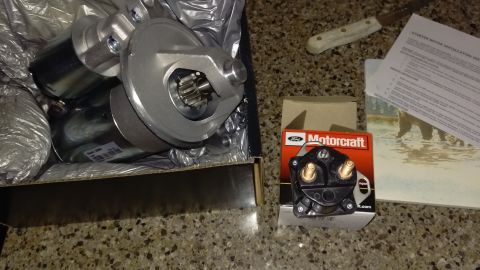 1994 Ford Bronco - Photograph of a starter motor in its box alongside a Motorcraft starter solenoid and a printed instruction sheet.