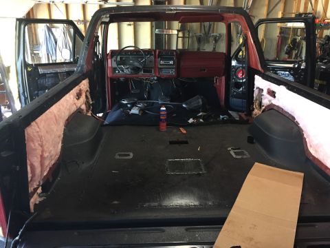 Stripped Ford truck interior with red dash and bare floor