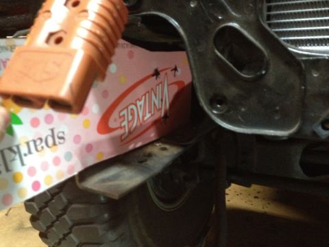 Orange electrical connector over a pink sticker with "VINTAGE" text, near a tire.
