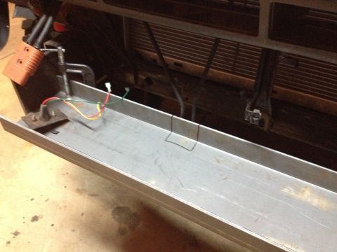 Close-up of vehicle front bumper with new aluminum channel and wiring.