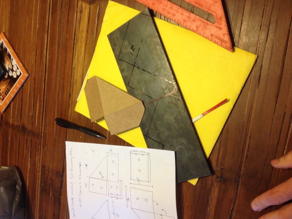 Sheet-metal fabrication templates with a square and a hand-drawn sketch on a table