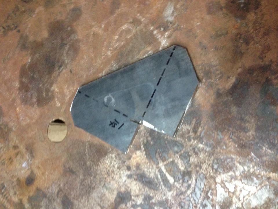 Cut sheet-metal bracket piece with marked fold lines on a steel surface
