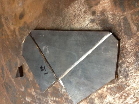 Bent sheet-metal bracket fabricated into a gusset shape on a steel surface