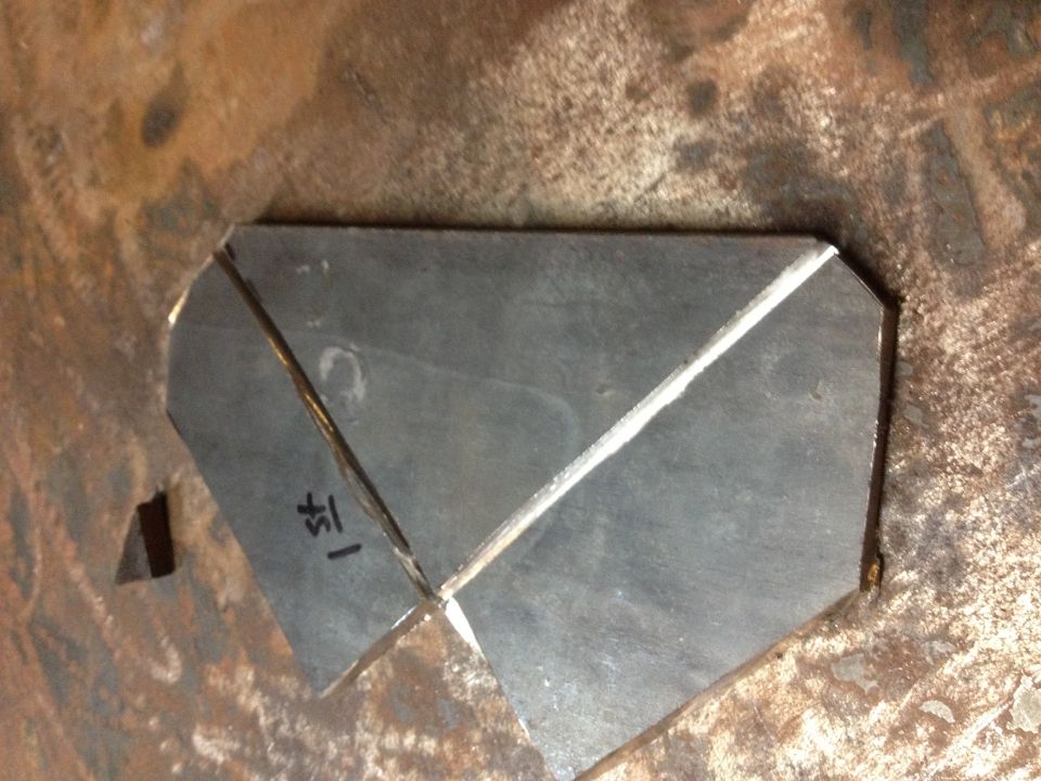 Bent sheet-metal bracket fabricated into a gusset shape on a steel surface