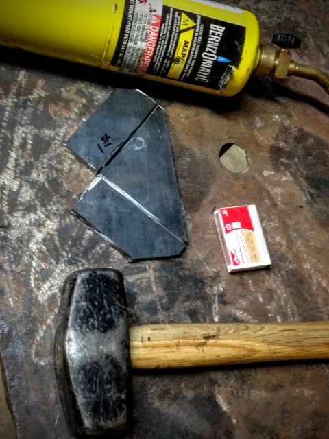 BernzOmatic torch, hammer and folded sheet-metal bracket on a steel bench