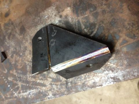 Welded sheet-metal gusset bracket with a fresh weld bead on a steel surface