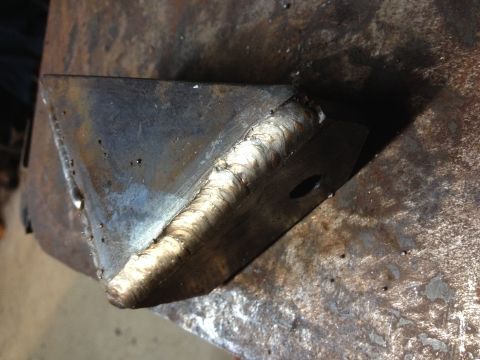 Close-up of a heavy weld bead joining two angled steel plates