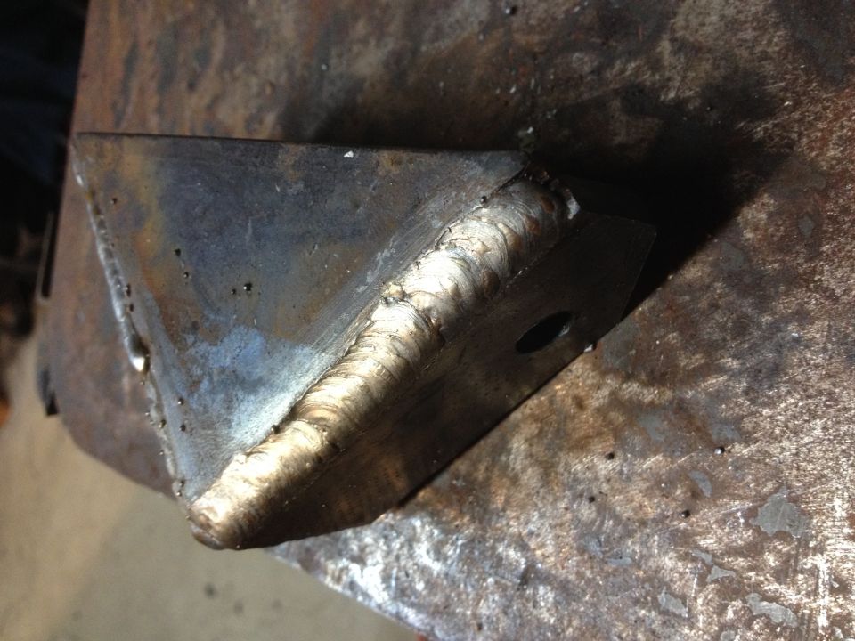 Close-up of a heavy weld bead joining two angled steel plates