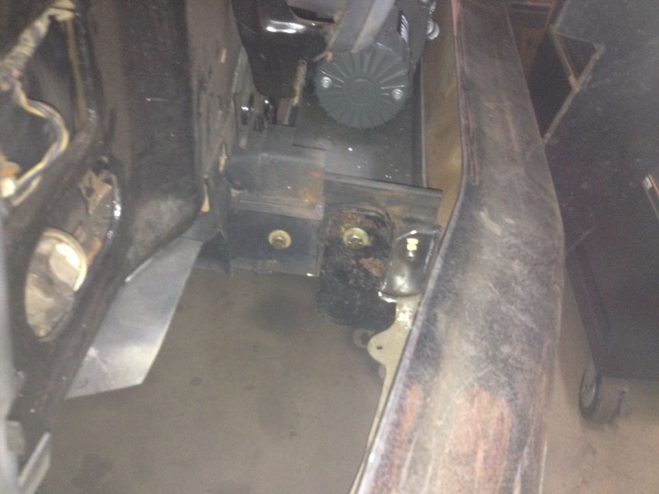Underbody view of a vehicle bracket mount with bolts and surrounding sheet metal