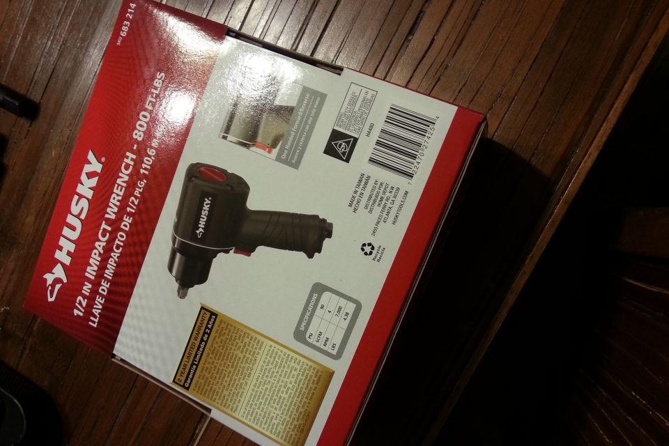 Husky 1/2 inch impact wrench retail box sitting on a wood table