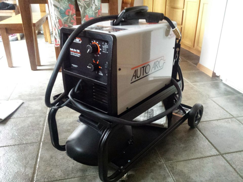 Auto Arc MIG welder on a wheeled cart in a tiled room