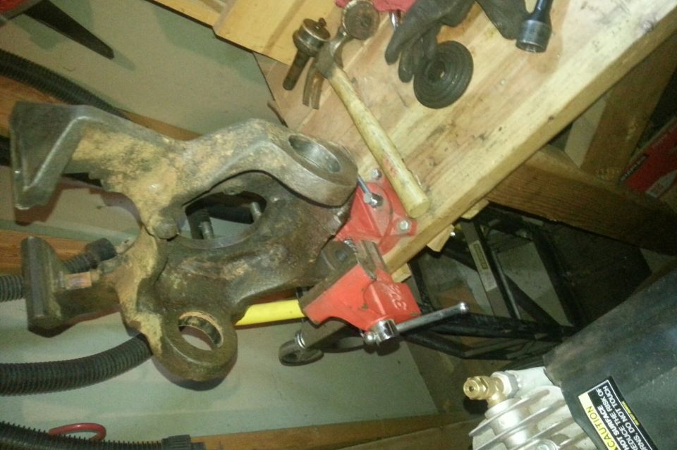 Steering knuckle clamped in a vise on a workbench