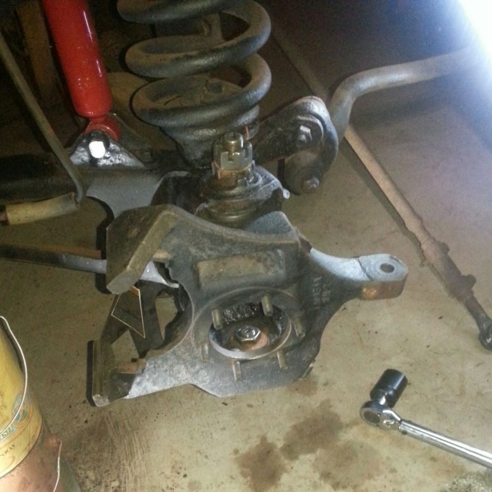 Front suspension with coil spring, shock, and steering knuckle installed on vehicle