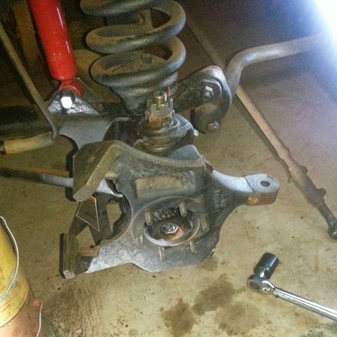 Front suspension with coil spring, shock, and steering knuckle installed on vehicle