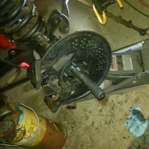 Vehicle suspension and brake assembly with coil spring and rotor.