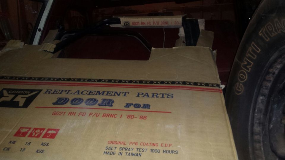 Cardboard box for Gordon replacement door for 1980-1986 Ford pickup/Bronco, with tire visible.