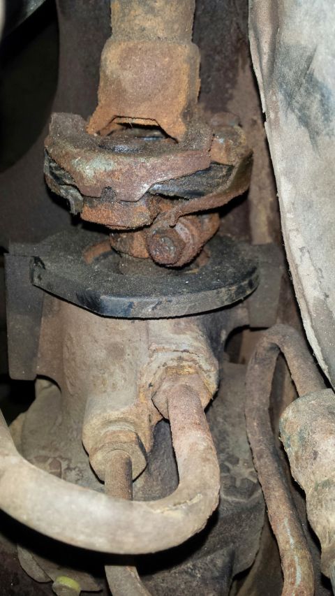 Rusted drive shaft support bearing and undercarriage components.