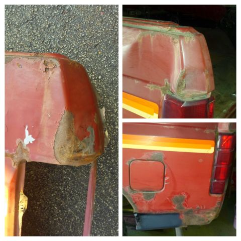 Heavily rusted rear quarter panel of a red vehicle with racing stripes.