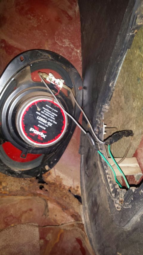 Sony Xplod speaker with visible wiring and rust in a vehicle.