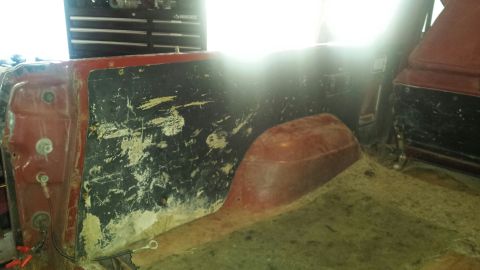 Interior of a red Ford Bronco, rear passenger side panel and wheel well.