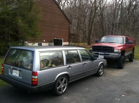 1991 Volvo 940 - A silver 1991 Volvo 940 wagon is parked next to a red pickup truck in a driveway.