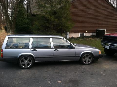 1991 Volvo 940 - A silver Volvo 940 station wagon is parked in front of a house, with another vehicle partially visible to the right.