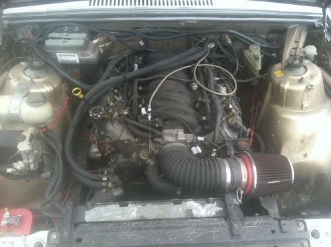 1991 Volvo 940 - The engine bay shows a modified engine with an aftermarket air intake and various hoses.