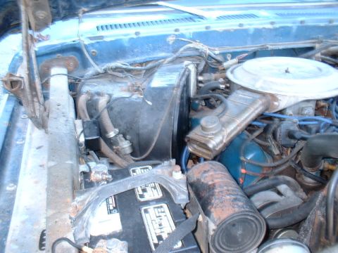 1978 Ford F-250 - Engine bay of a 1978 Ford F-250, the battery and air cleaner assembly.