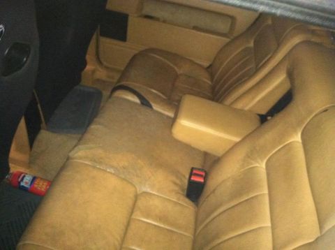 1991 Volvo 940 - The interior of a car shows the back seat and a fire extinguisher on the floor.