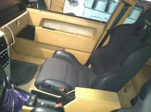 1991 Volvo 940 - The interior of a 1991 Volvo 940 shows tan door panels and black racing seats.