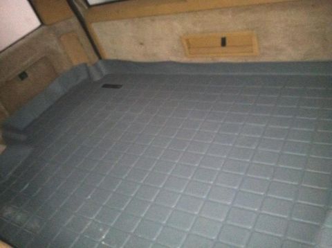 1991 Volvo 940 - The cargo area of a car is covered by a durable rubber mat with a diamond pattern.