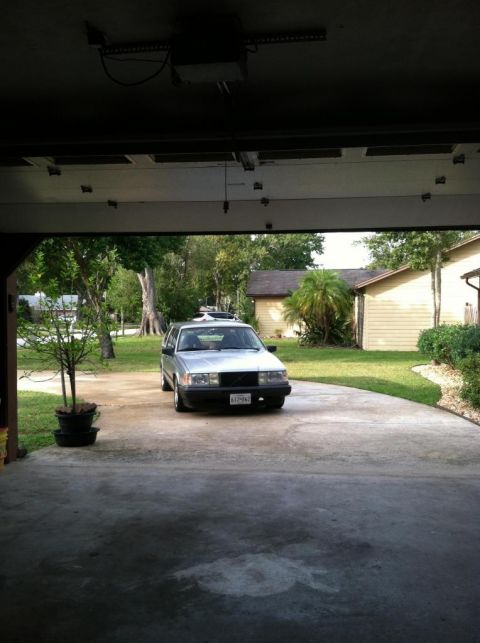 1991 Volvo 940 - Silver 1991 Volvo 940 sedan parked in a driveway, seen from inside a garage.