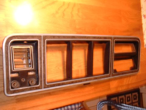 1978 Ford F-250 - Dashboard trim panel with faux woodgrain finish and multiple openings for gauges and vents.